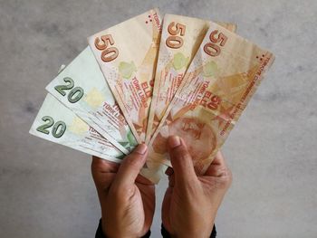 Cropped image of hands holding turkish lira currency