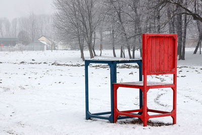 View of snow covered field against trees during winter