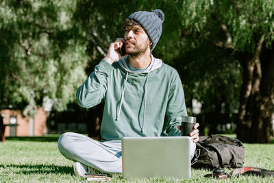 Man using mobile phone while sitting on grass
