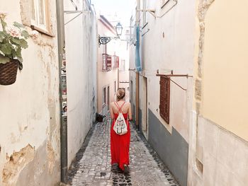 Rear view of man standing by red wall