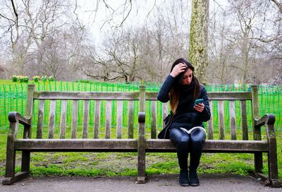 Rear view of woman standing by tree