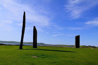 Wooden posts on field against sky