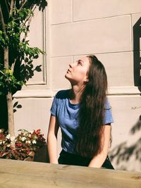 Young woman looking at potted plant