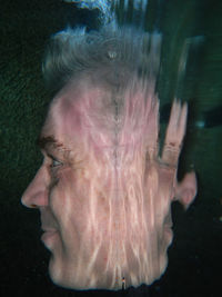 Close-up of man with reflection on water in pool