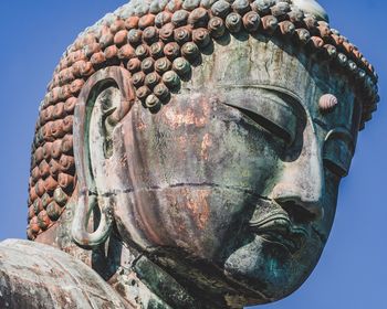 Close-up of buddha statue against clear sky