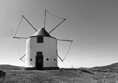 Traditional windmill on field against sky