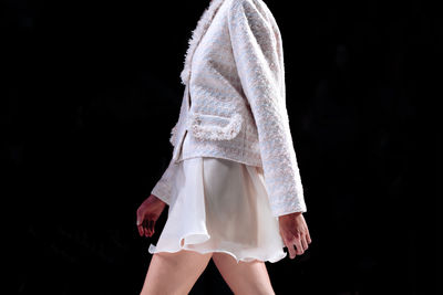 Classy white silk skirt and tweed jacket, woman's chic outfit on black background