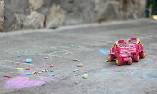 Roller skate and chalks on footpath