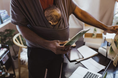 Midsection of man working on table