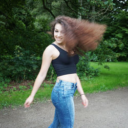 Full length of woman standing on tree trunk