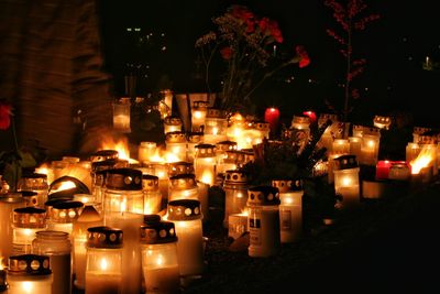Lit candles at cemetery during night