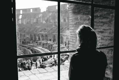 Woman looking at coliseum through window