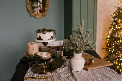 Festive decor of the dining table for christmas with a cake on the background of lights