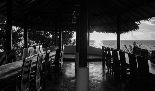 Chairs on beach by sea against sky