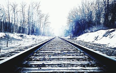 Railroad track passing through snow covered landscape
