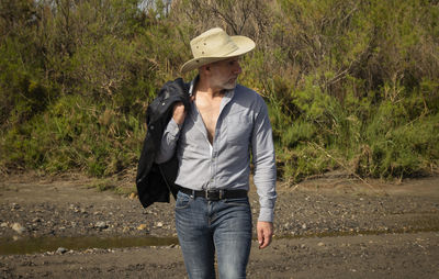 Adult man in cowboy hat in oasis of desert. almeria, spain