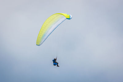 Low angle view of person paragliding against sky