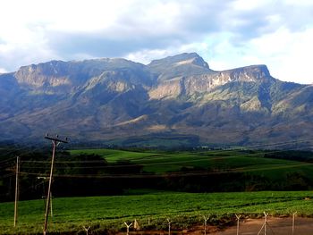 Scenic view of field and mountains against sky