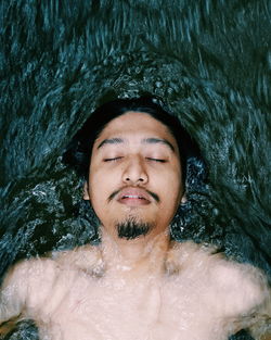 High angle view of shirtless man swimming in water