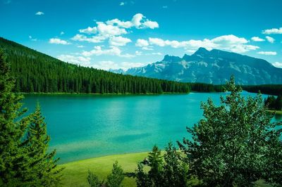 Scenic view of lake and mountains against blue sky