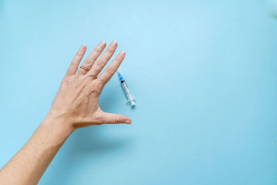 Close-up of hand holding blue background