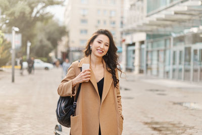 Lifestyle portrait pretty asian kazakh woman with brilliant smile on street