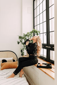 Woman sitting by window at home