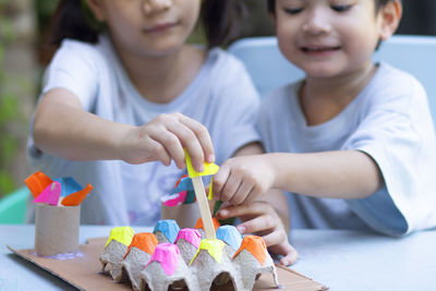 High angle view of siblings playing on table