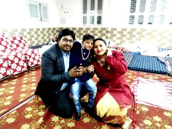 Full length portrait of happy young couple sitting outdoors