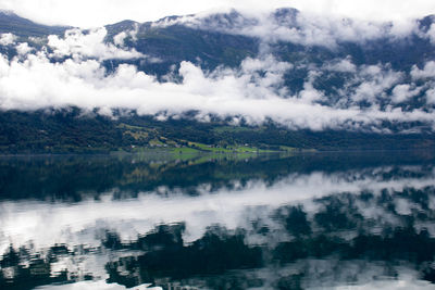 Scenic view of lake by mountains against sky