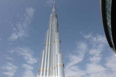 Low angle view of modern building against cloudy sky