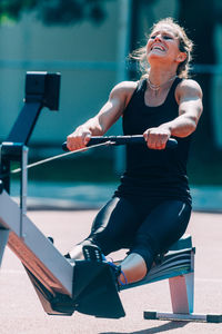 Woman exercising in gym during sunny day