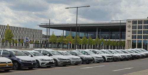 Cars on street in city against sky