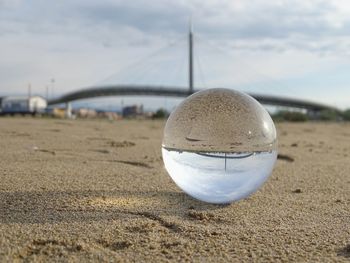 Close-up of crystal ball on sand