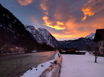 Scenic view of snow covered mountains at sunset
