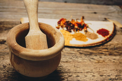 Spices by mortar and pestle on table