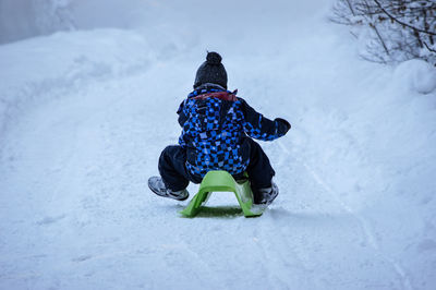 Rear view of child on snow field