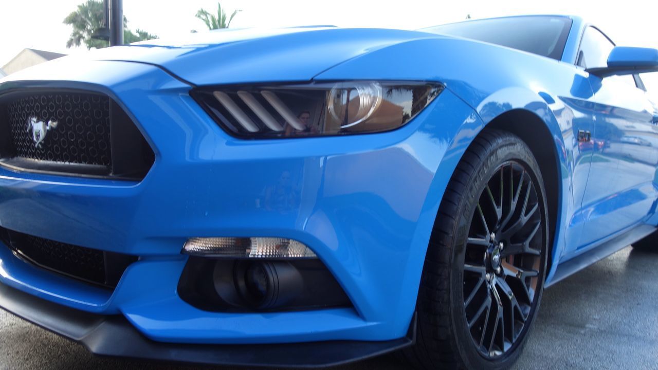 CLOSE-UP OF BLUE CAR IN CITY