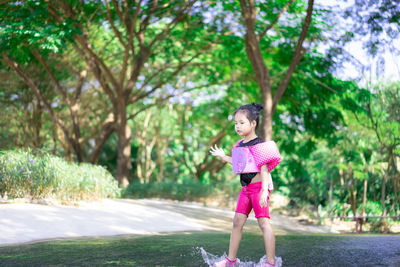 Full length of woman standing by tree against plants