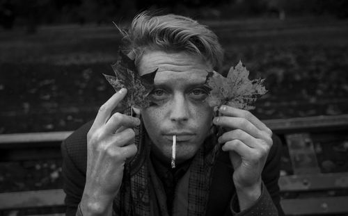 Close-up portrait of man holding leaves