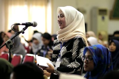 Young woman wearing hijab giving speech
