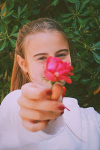 Close-up portrait of girl holding flowers