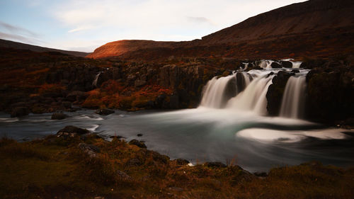 Scenic view of waterfall against sky