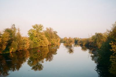 Scenic view of lake by trees against clear sky