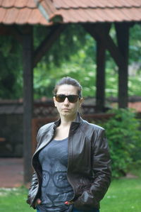 Portrait of woman wearing sunglasses standing in park