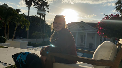 Portrait of woman sitting against house