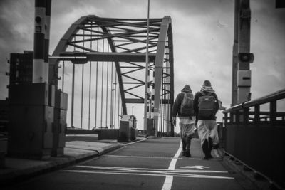 Rear view of people walking on road in city