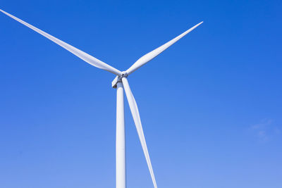 Low angle view of windmill against clear blue sky