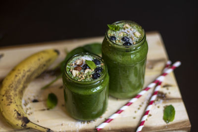 Close-up of green drink in jars by banana on table