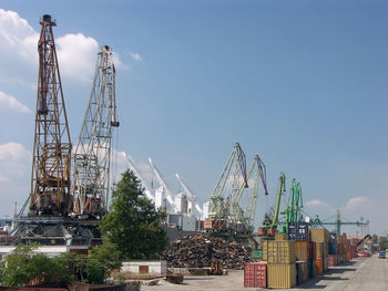 Port of transhipment with cranes and metal freight containers waiting for loading on ship